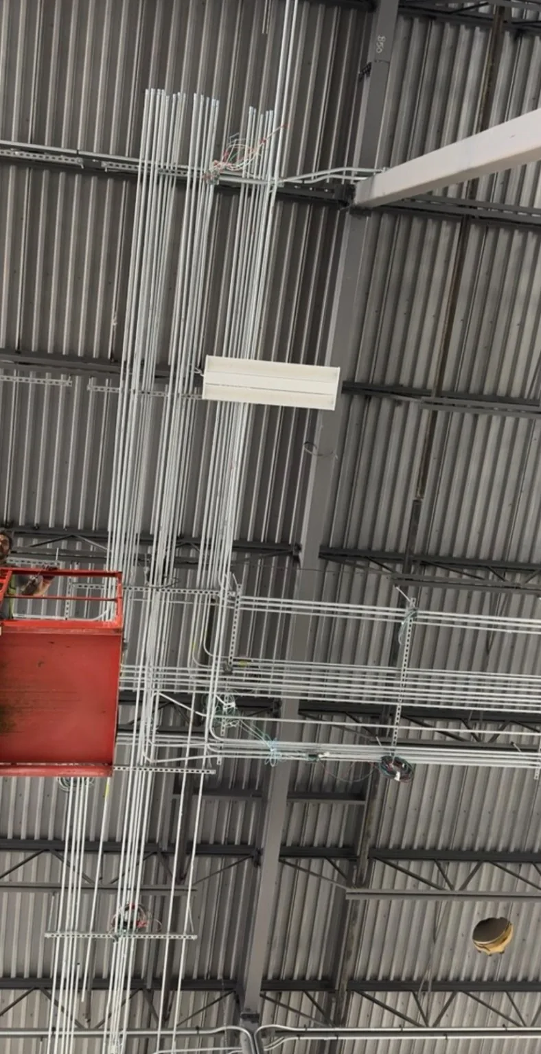High-bay commercial conduit pathways installed above an active construction area