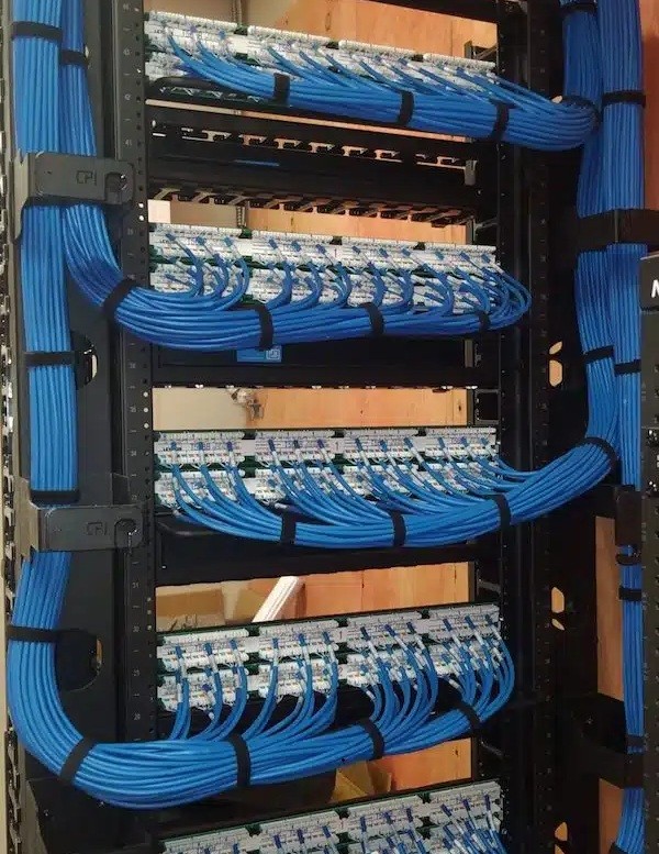 Organized blue structured cabling terminated on patch panels in a communications rack